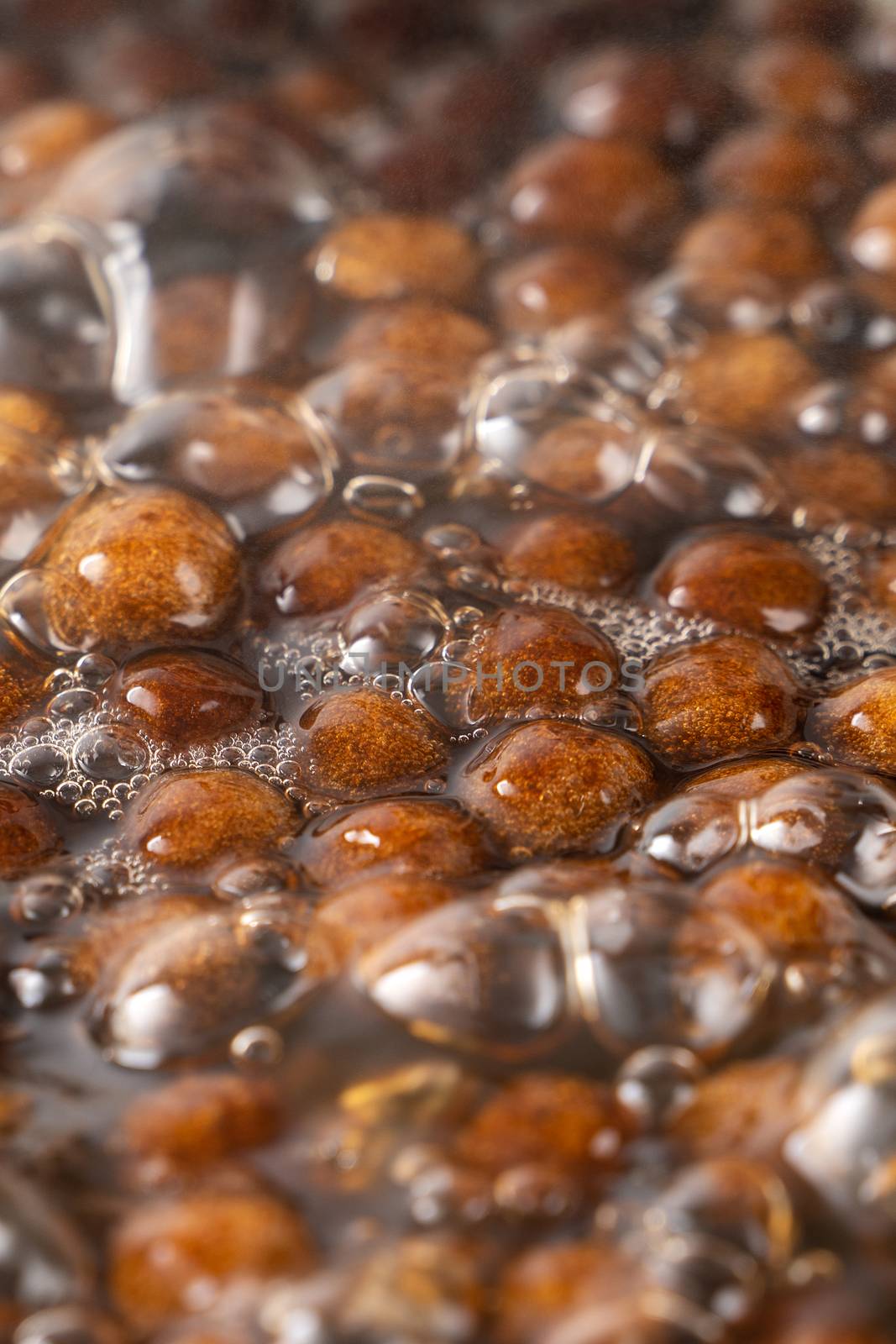 Cooking, boiling brown sugar flavor tapioca pearl balls, ingredient of bubble tea, preparing food and drink, close up, recipe cookbook steps design concept.