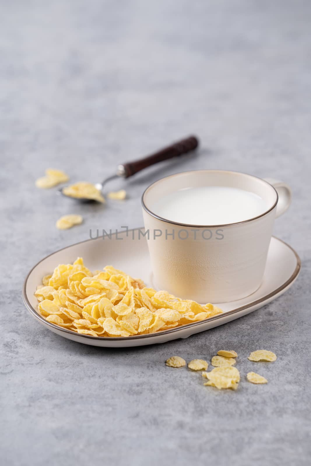 Corn flakes bowl sweeties with milk on gray cement background, c by ROMIXIMAGE