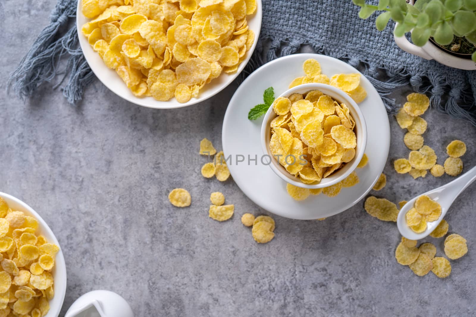 Corn flakes bowl sweets on gray cement background, top view flat by ROMIXIMAGE