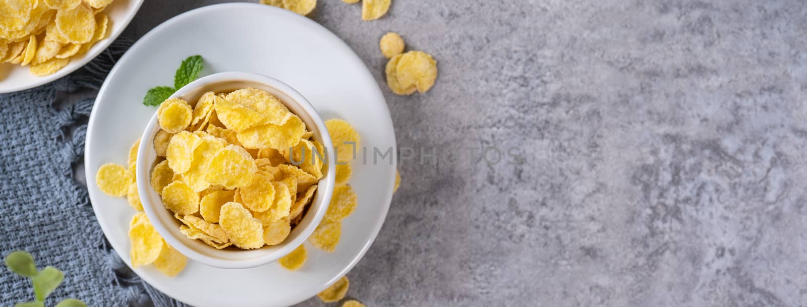 Corn flakes bowl sweets on gray cement background, top view flat by ROMIXIMAGE