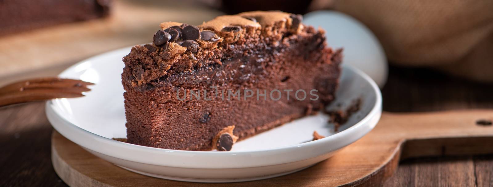 Chocolate flavor Taiwanese traditional sponge cake (Taiwanese castella kasutera) on a wooden tray background table with ingredients, close up.