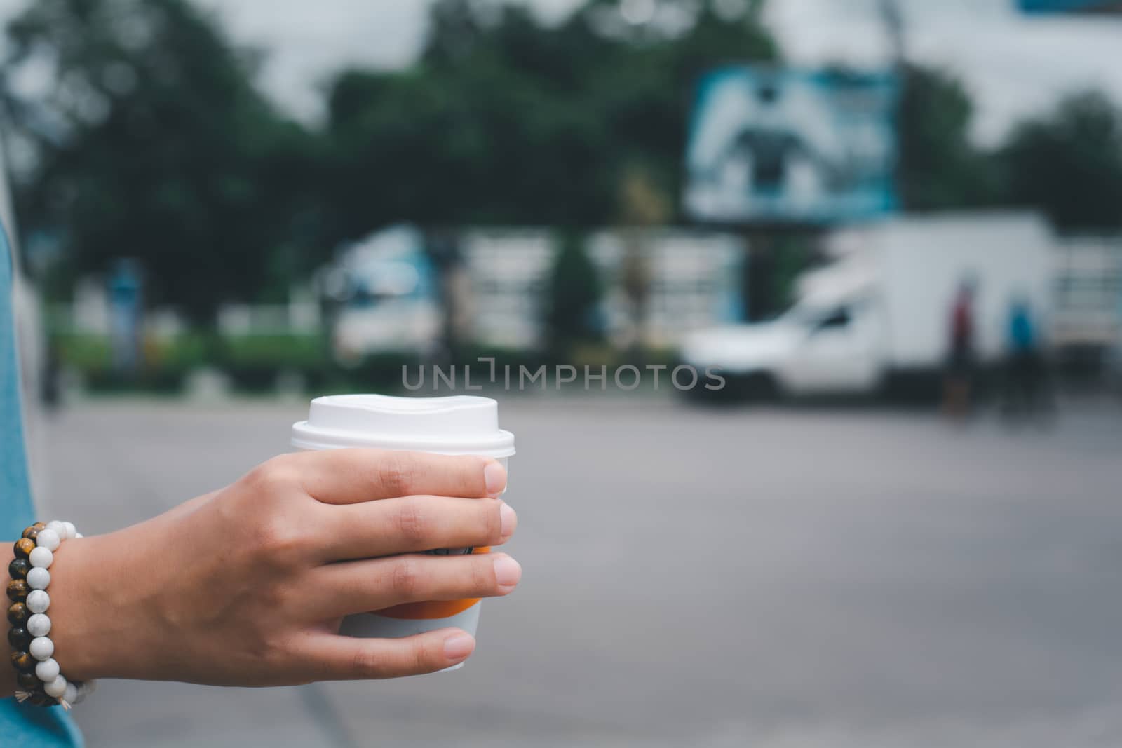 Hand holding plastic cup of hot coffee with copy space. Take coffee to home in new normal concept.