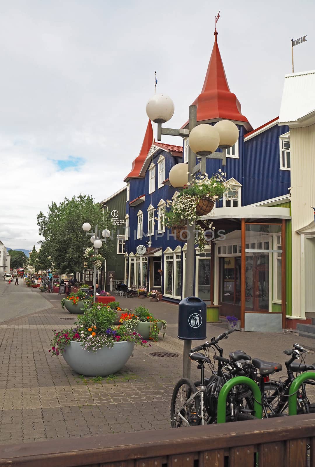 street in Akureyri centre with blue house, flowerpots and bikes -  in north Iceland