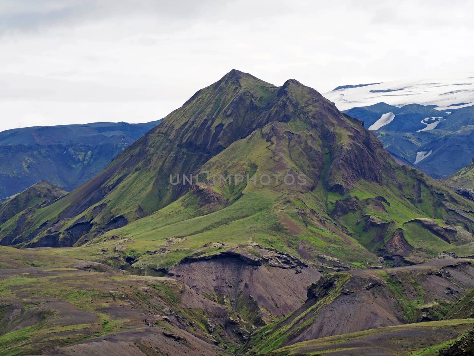 thorsmork national park in iceland  - green mountain with steep path with green grass moss and snow