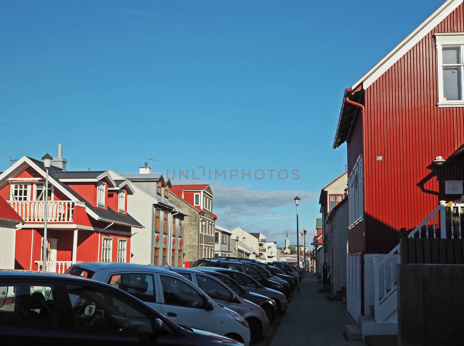 street in Reykjavik with red sheet metal houses with bright blue sky