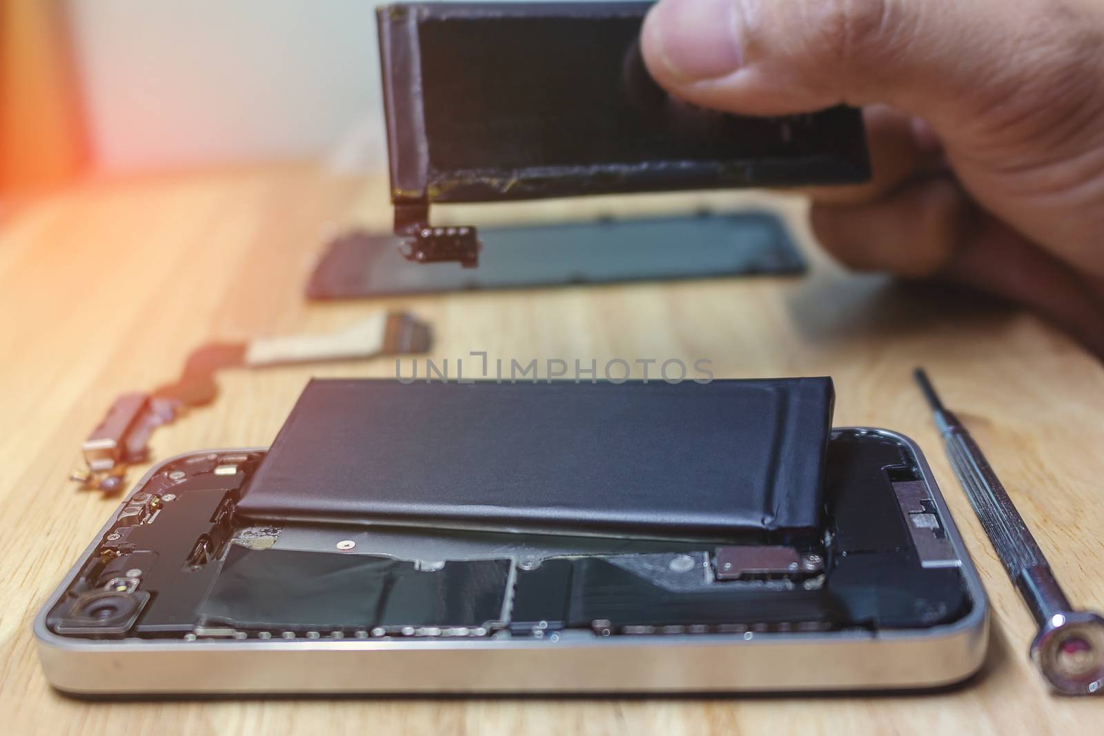 Iphone repairs install battery into the motherboard for smartphone By technician on desk