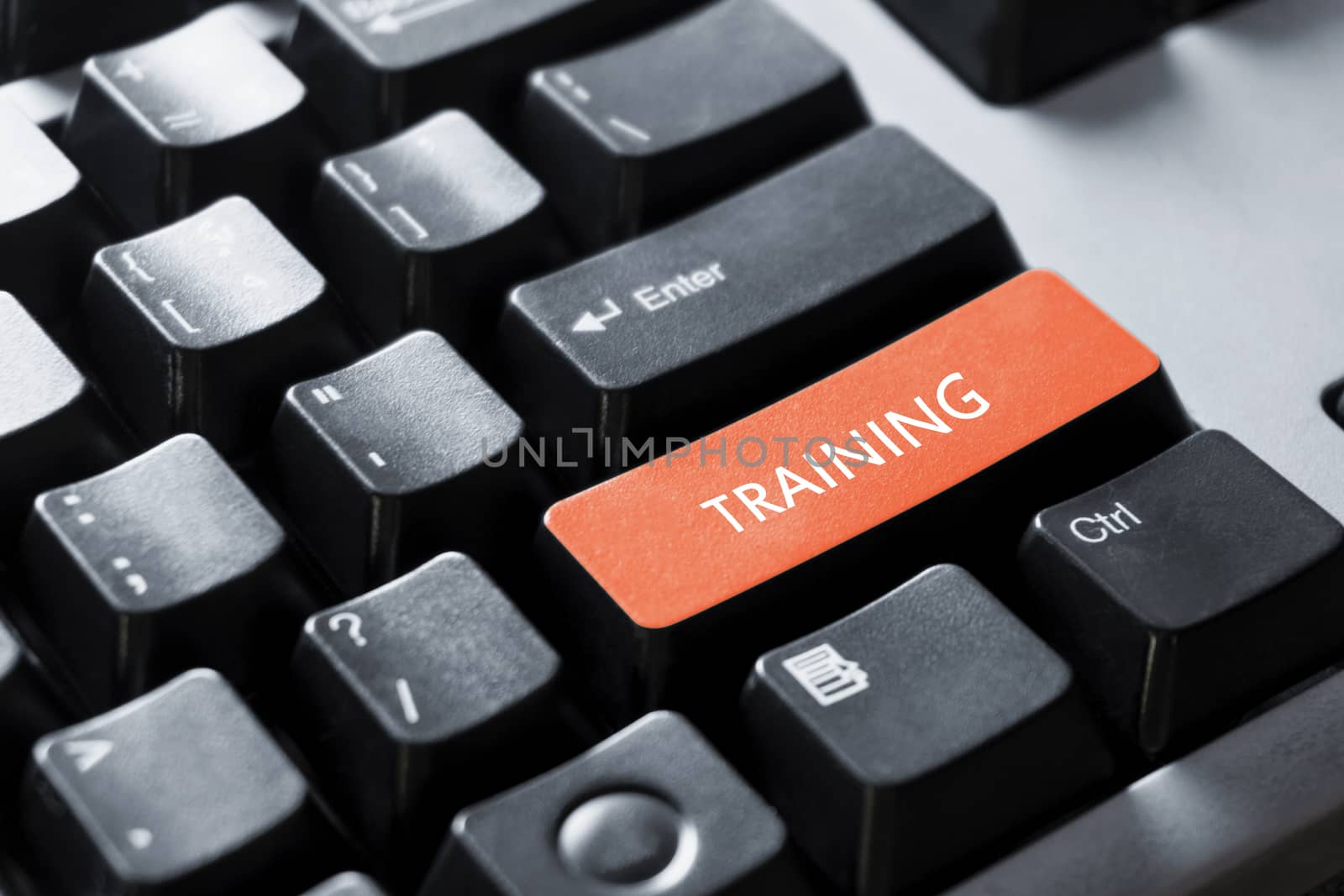 The concept of the orange button on the computer that is design to enter a training key font on a black PC keyboard for office the internet or work.