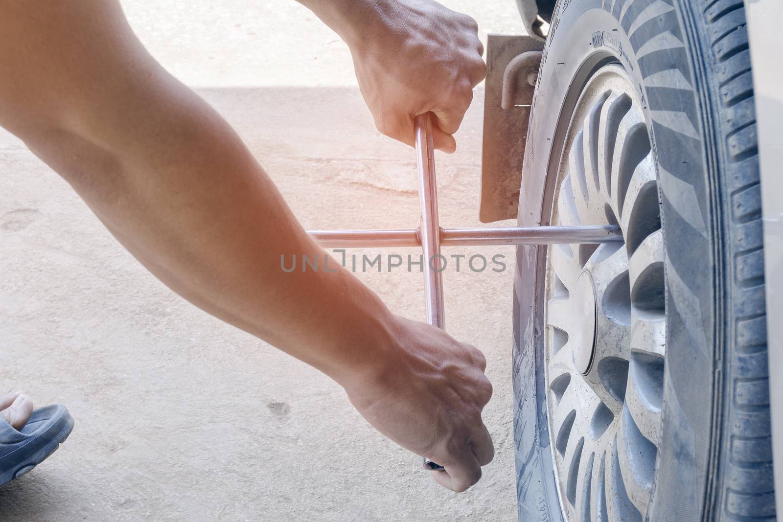 The mechanic tire repairs are removing the wheels. With tools