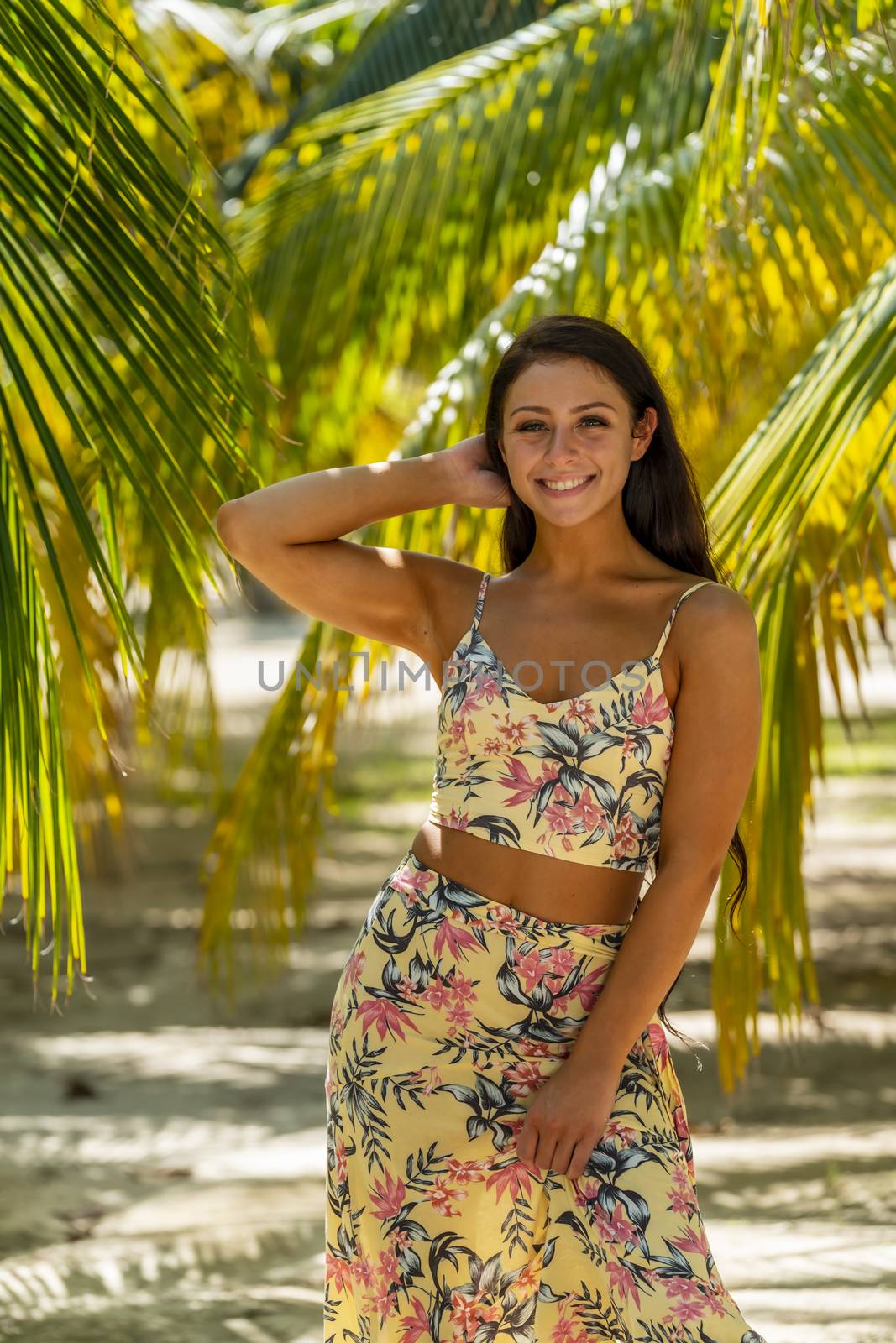 A beautiful brunette model enjoys the soft light under a palm tree in the Yucatán Peninsula near Merida, Mexico