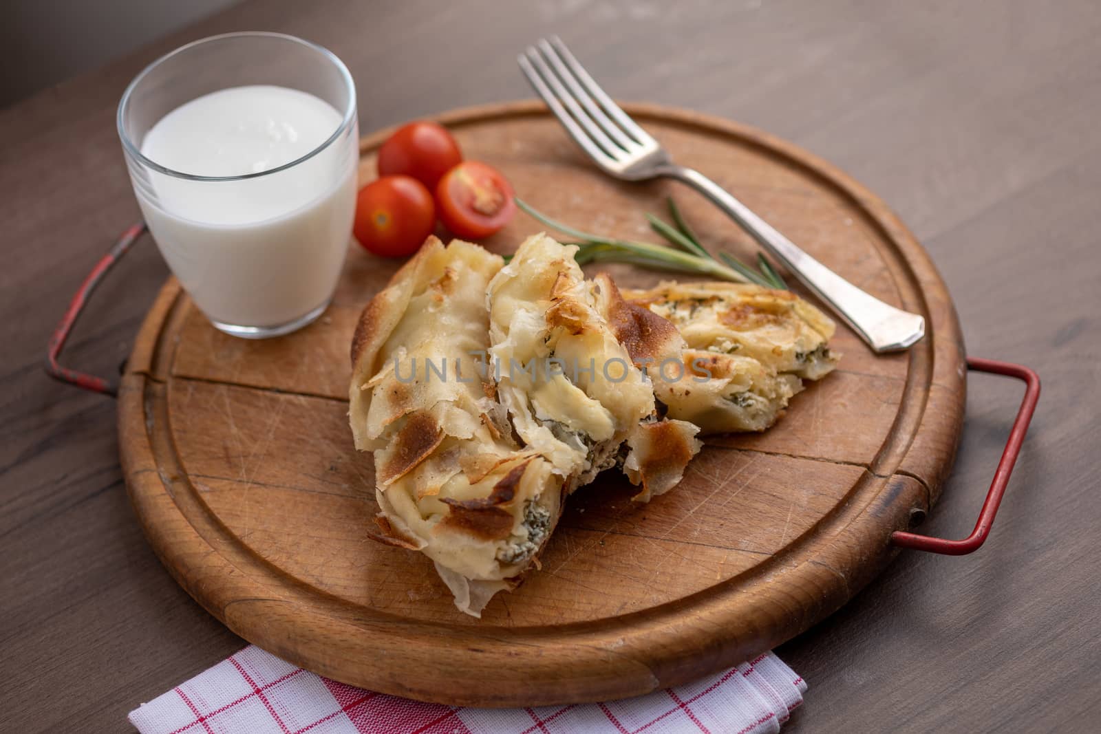 Traditional balkan breakfast - Burek pie with cheese and spinach served on vooden table