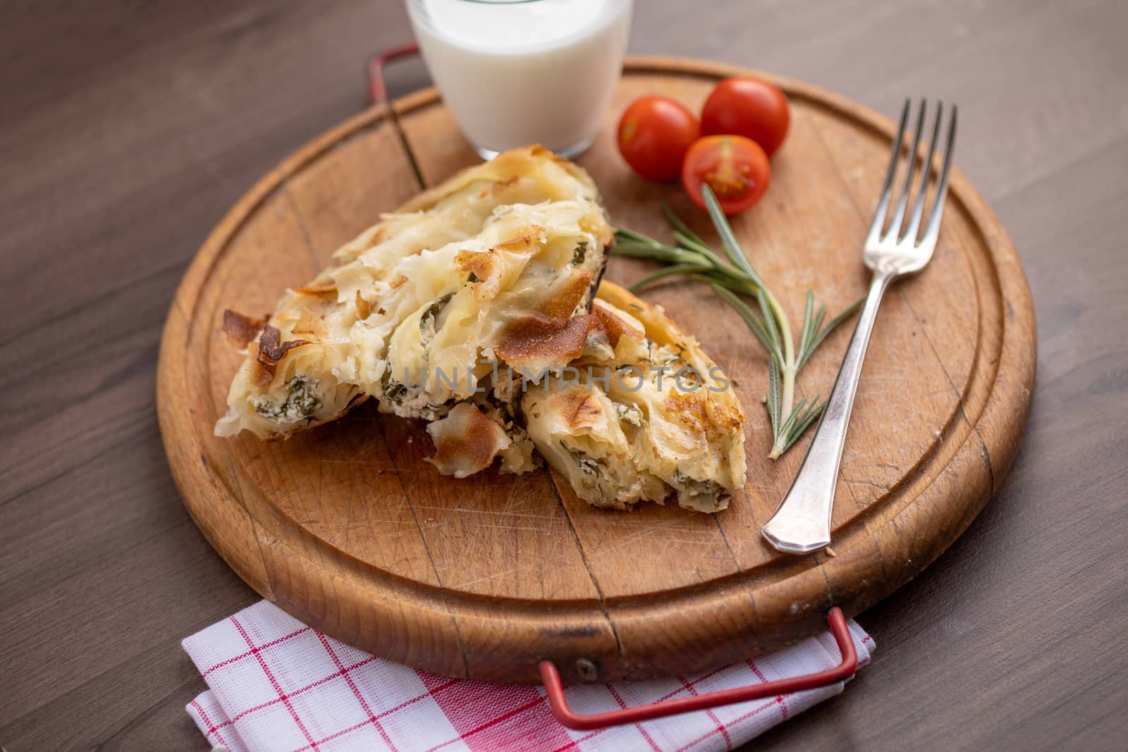 Traditional balkan breakfast - Burek pie with cheese and spinach served on vooden table