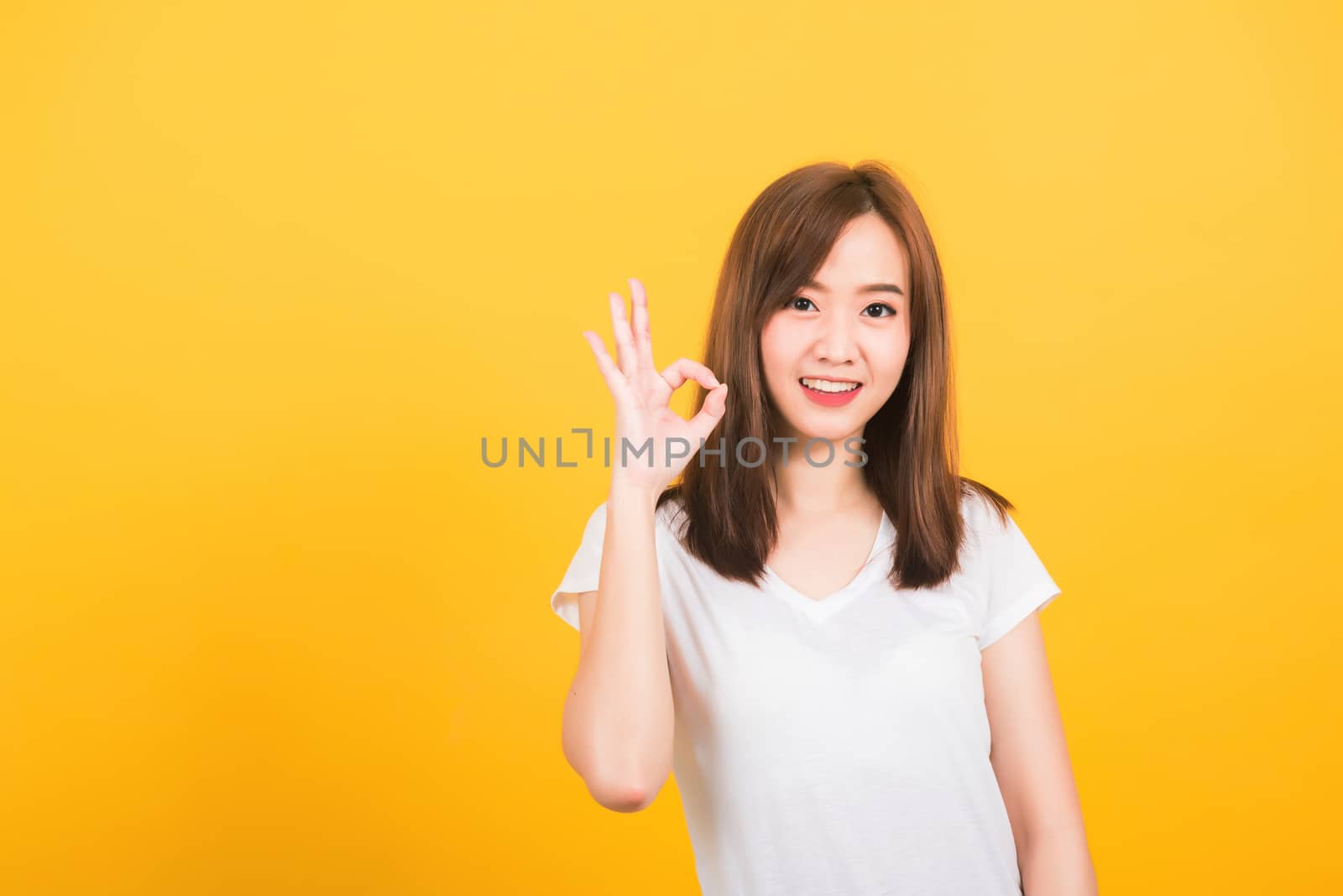 woman teen standing wear t-shirt showing gesturing ok sign by Sorapop