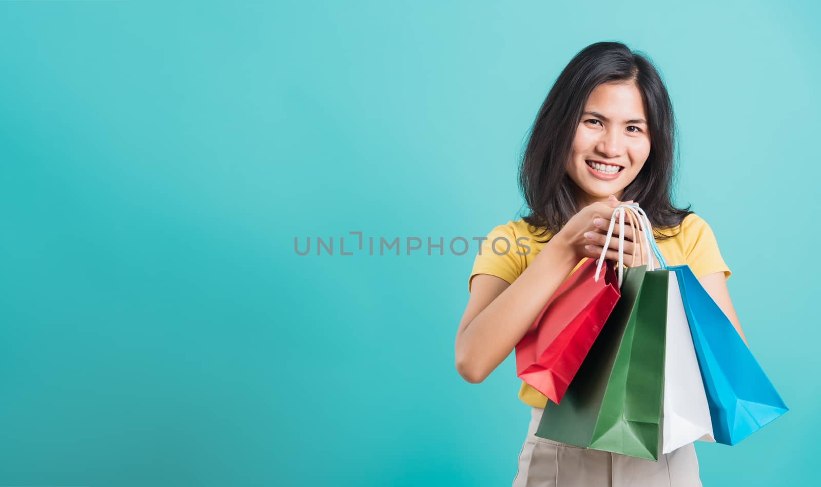 woman standing wear yellow t-shirt, holding shopping bags multi  by Sorapop