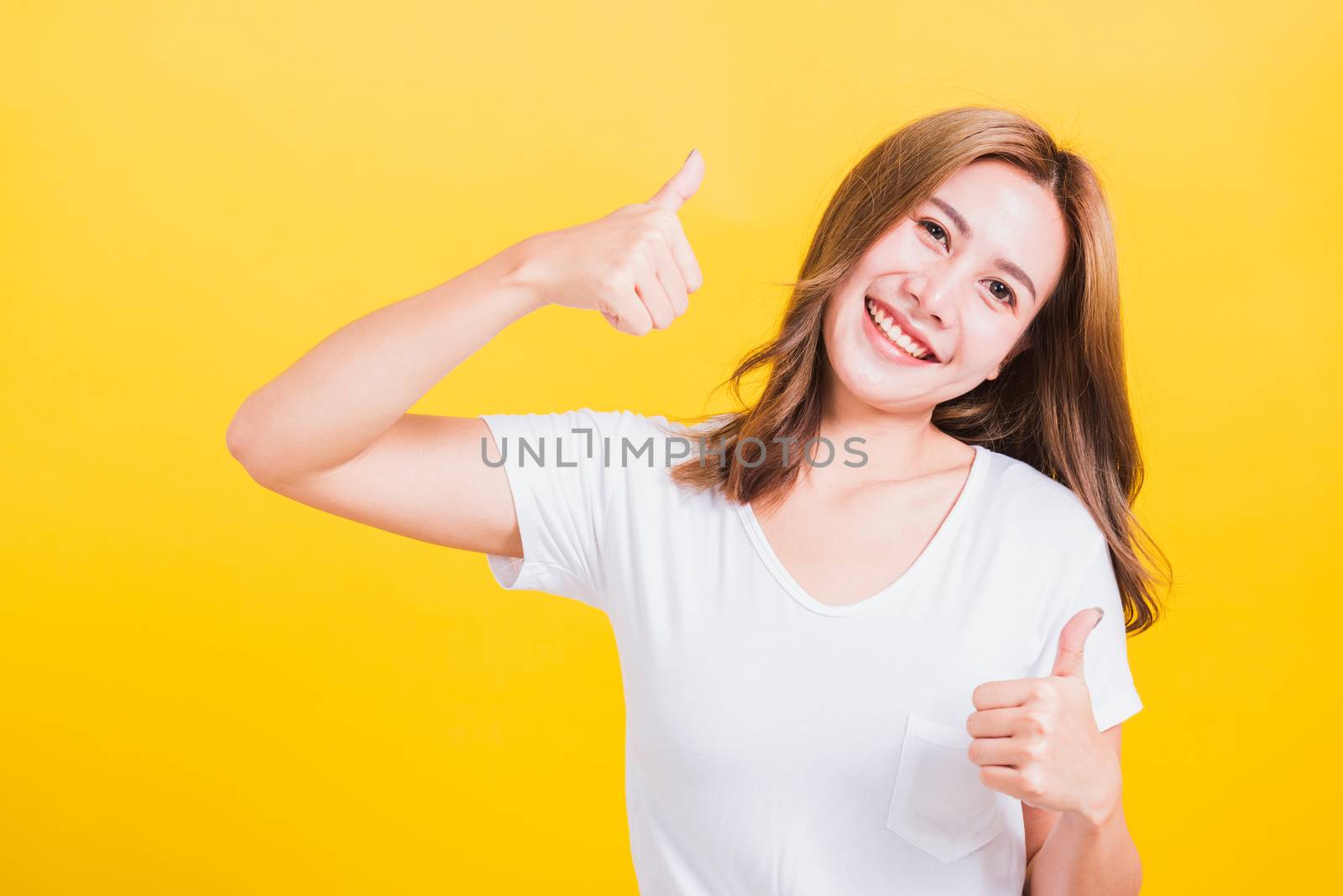 woman smile wear white t-shirt successful woman giving two thumb by Sorapop
