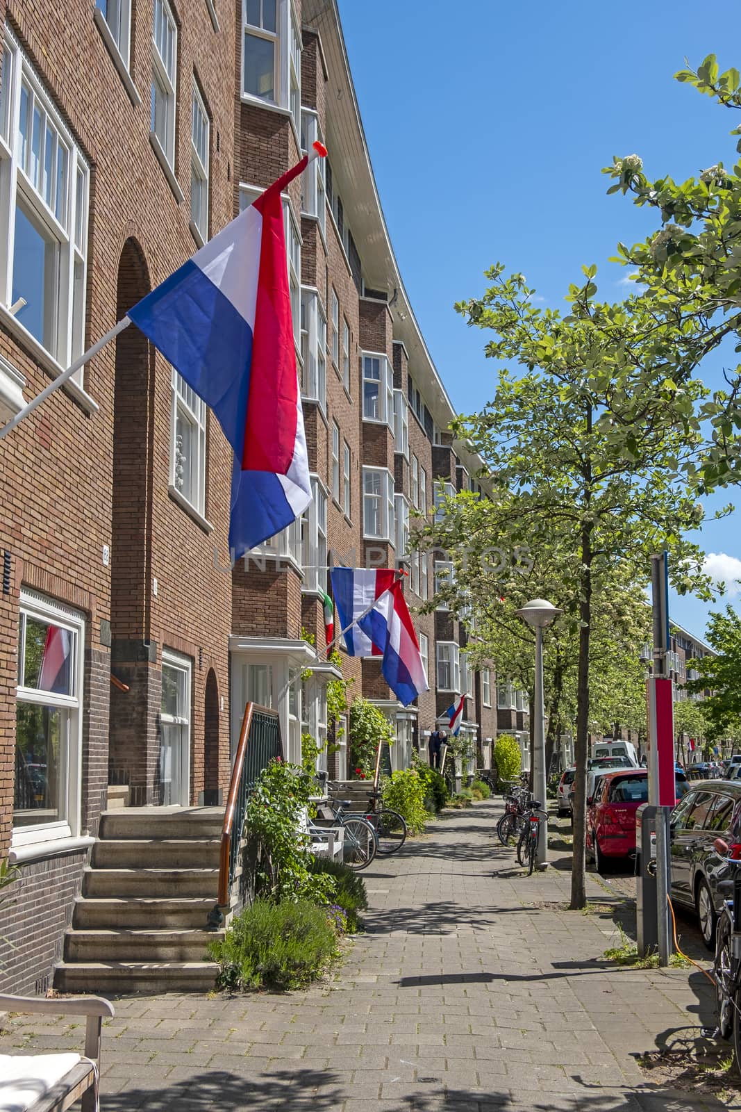 Flags on the houses in Amsterdam in the Netherlands at kingsday by devy