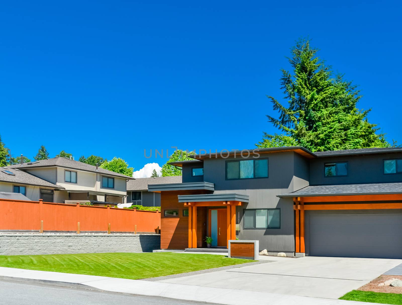 Newly renovated family house in Vancouver, British Columbia. Residential house with wide garage door and concrete driveway