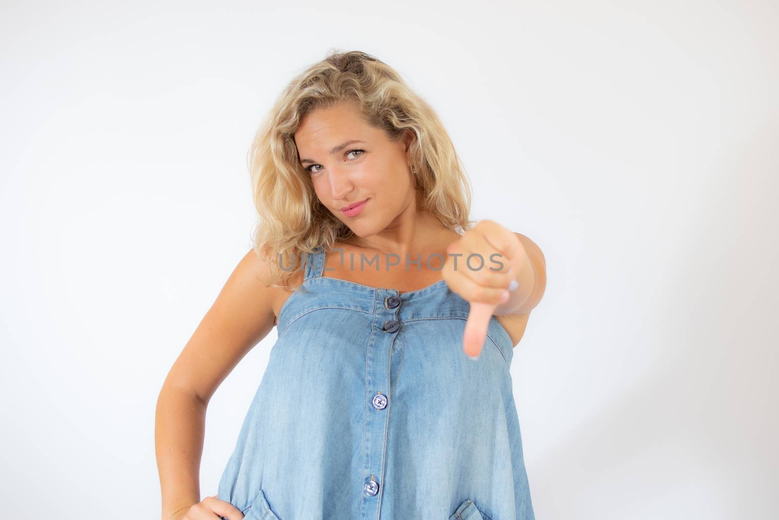 Pretty blonde woman in blue dress making finger down gesture