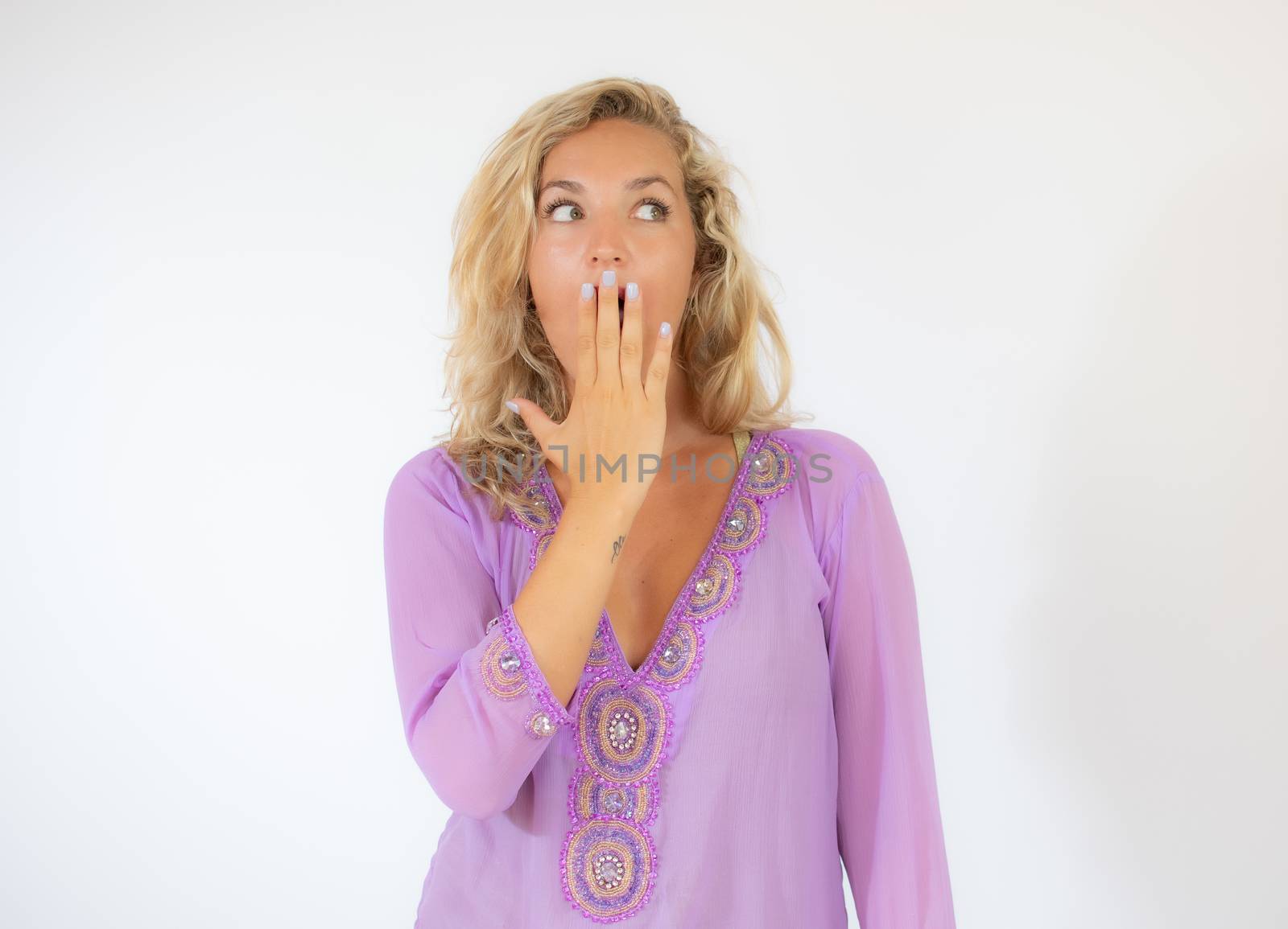 Pretty blonde woman in lila caftan amazed on white background