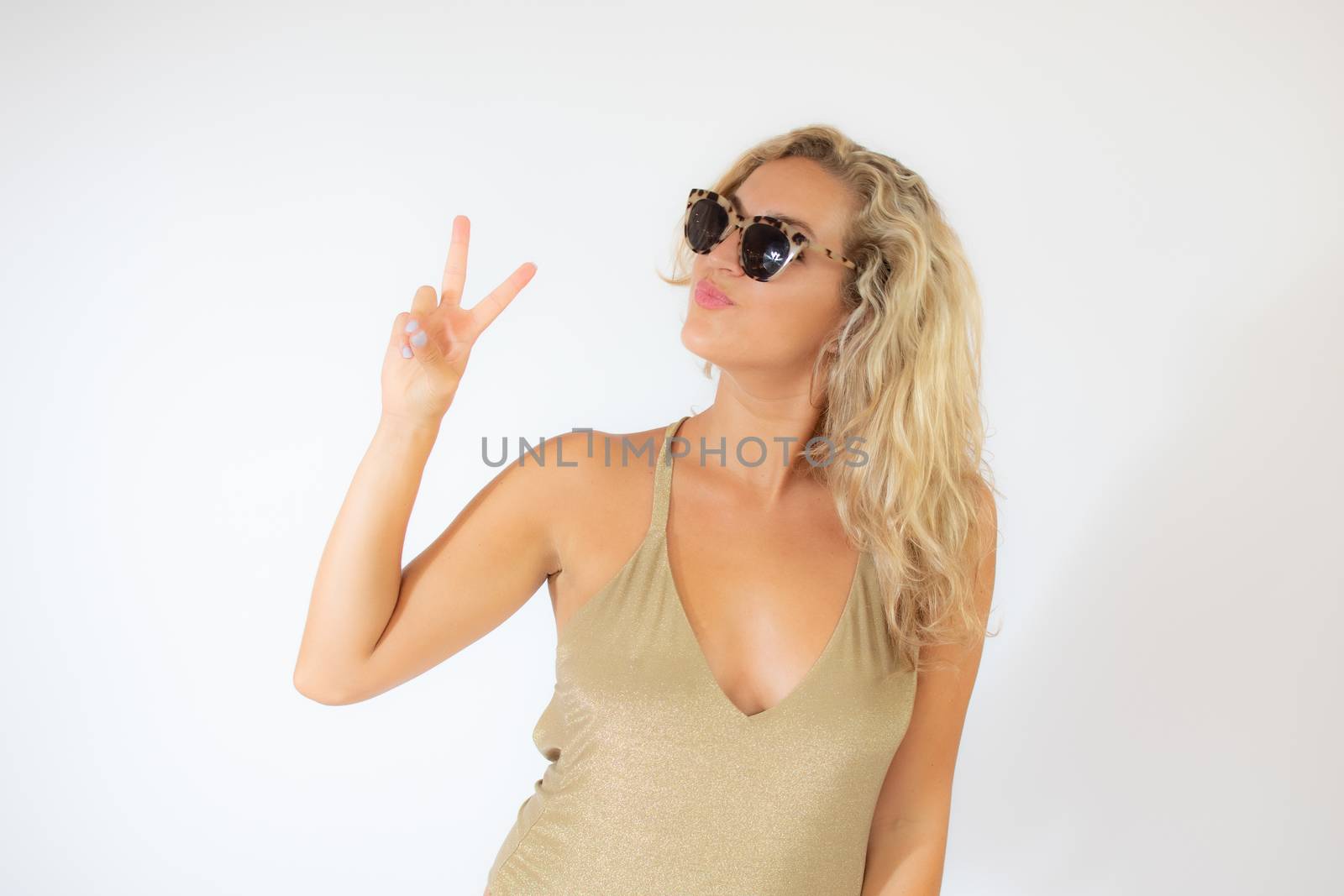 Pretty smiling blonde woman with sunglasses in golden swimsuit