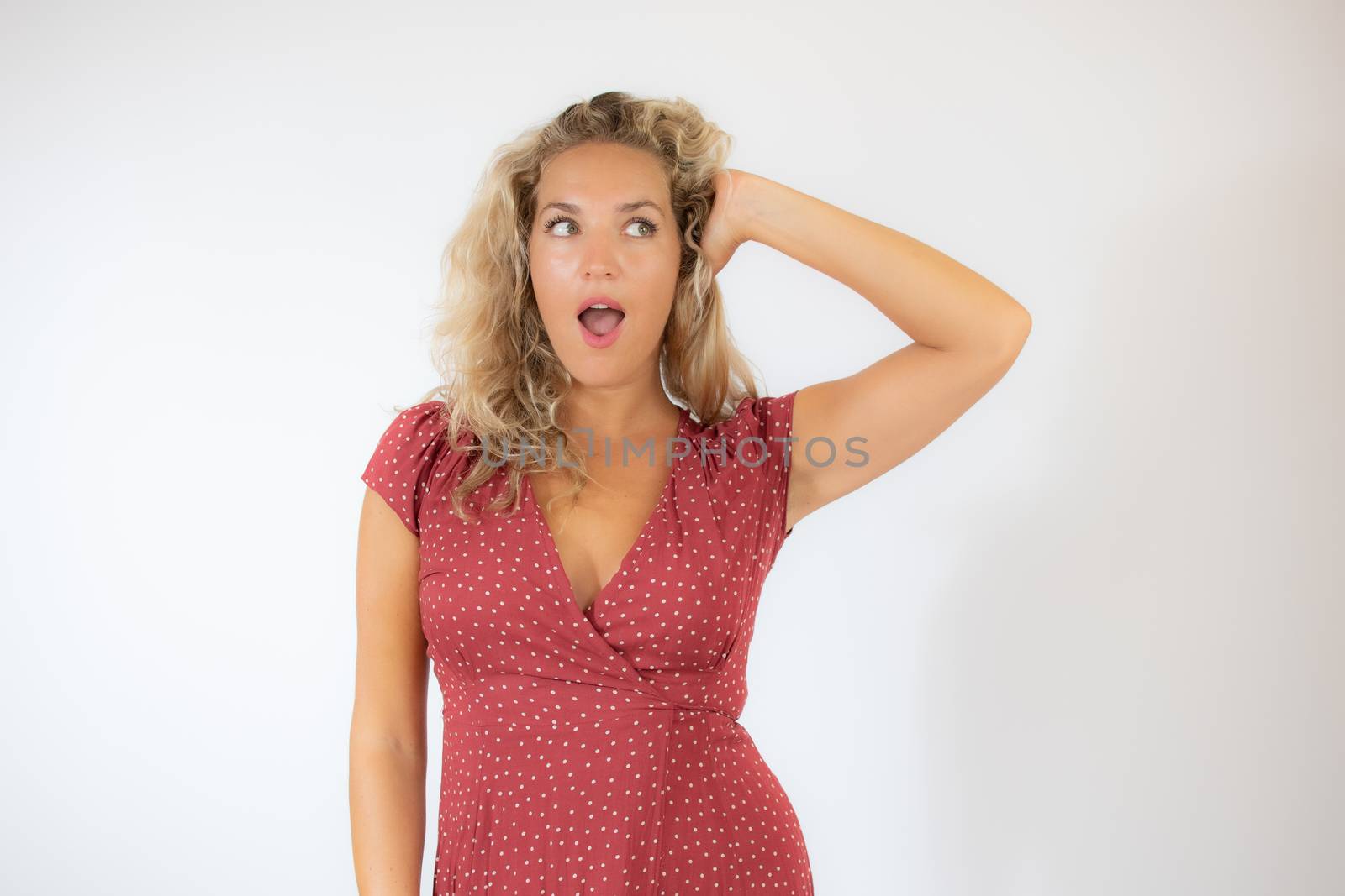 Beautiful surprised blonde woman in a red dress