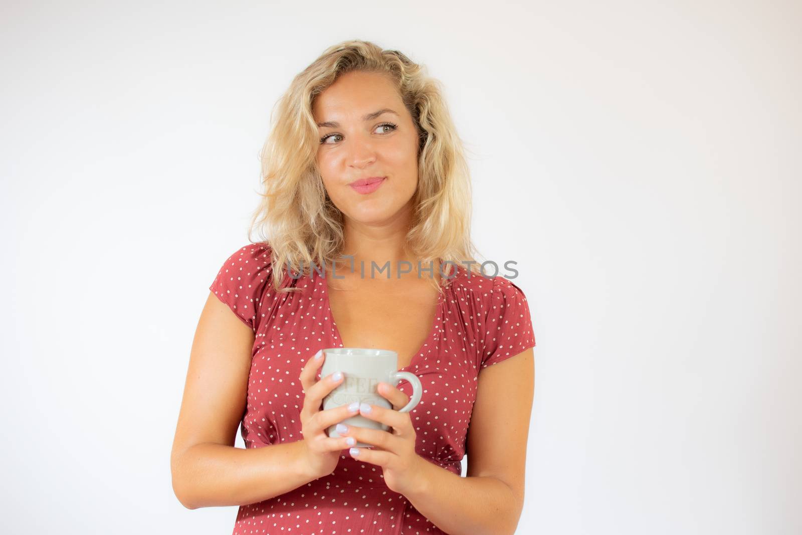 Pretty blonde woman in red dress with a cup of coffee