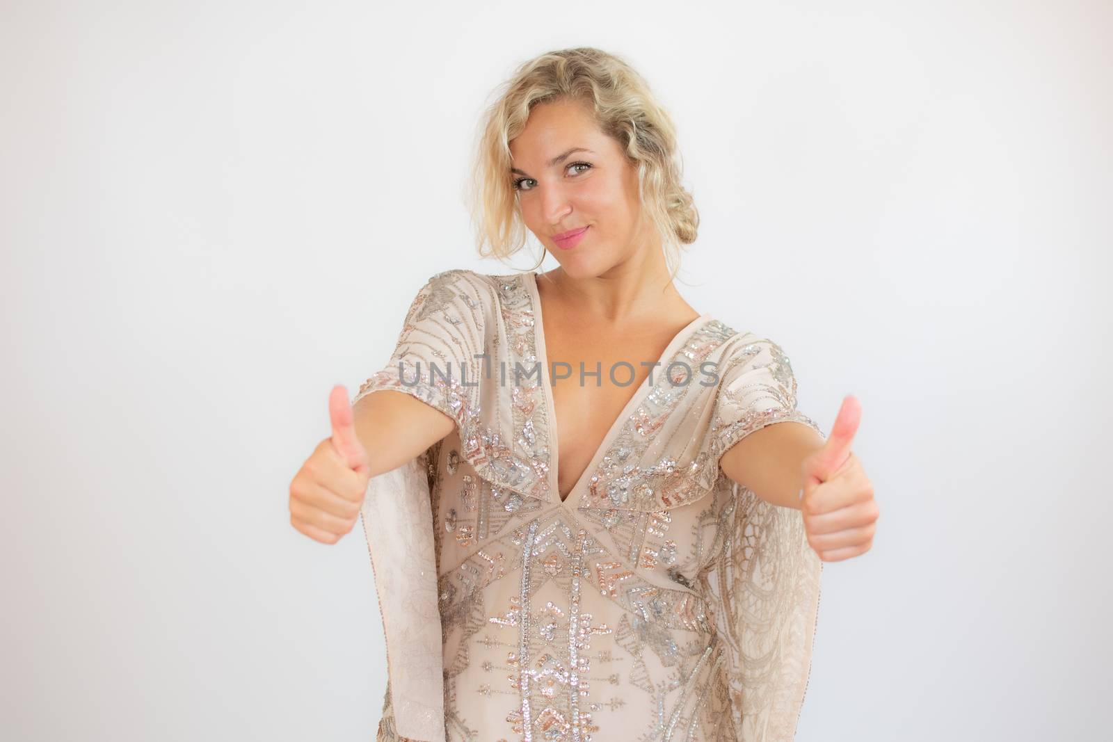 Smiling pretty blonde woman in a party dress gesturing on white background