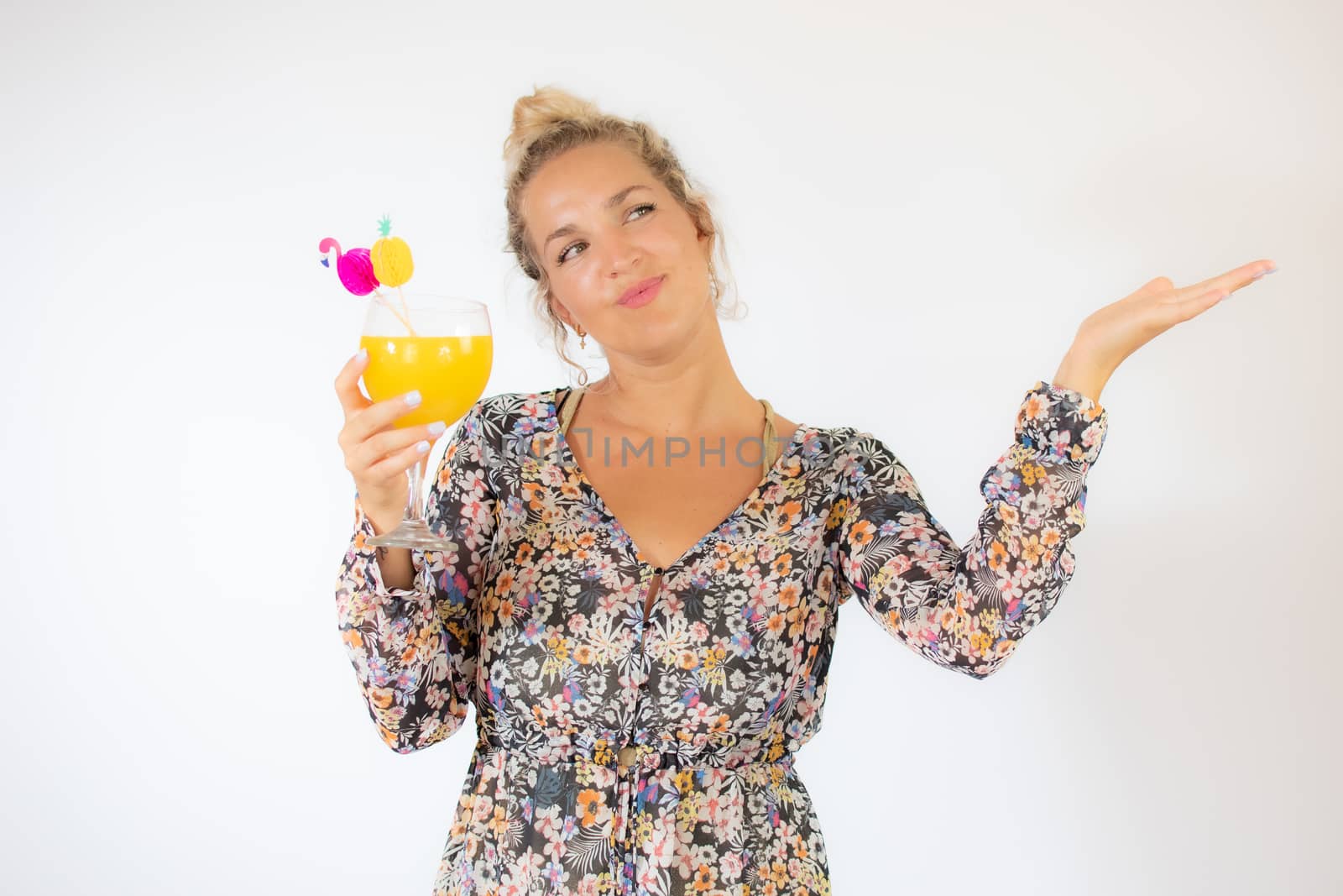 Pretty blonde woman in a flowery dress with a cocktail on white background