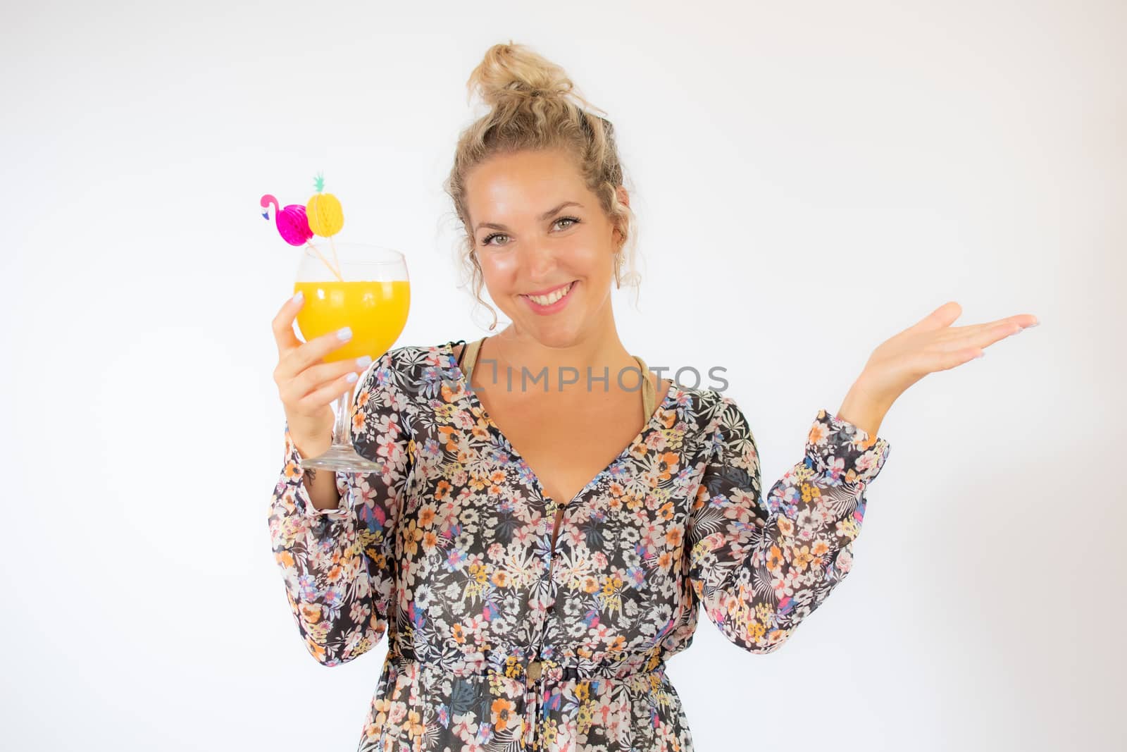Pretty blonde woman in a flowery dress with a cocktail on white background