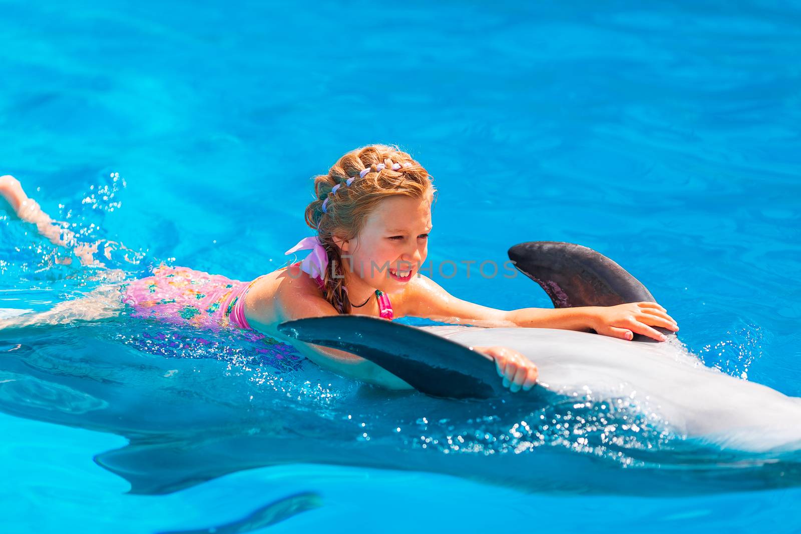 Happy little girl swimming with dolphins in Dolphinarium by Len44ik