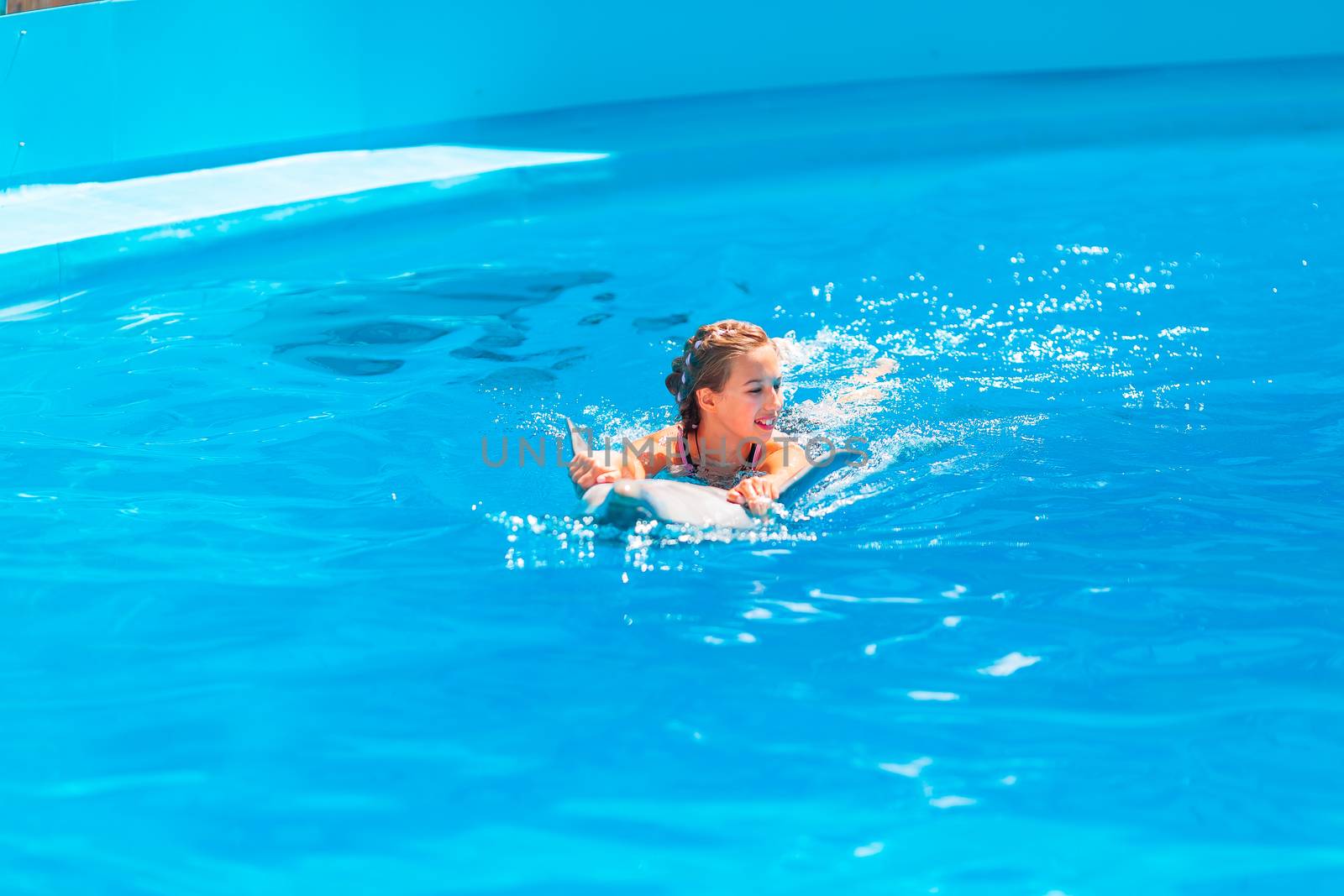 Happy little girl swimming with dolphins in Dolphinarium by Len44ik