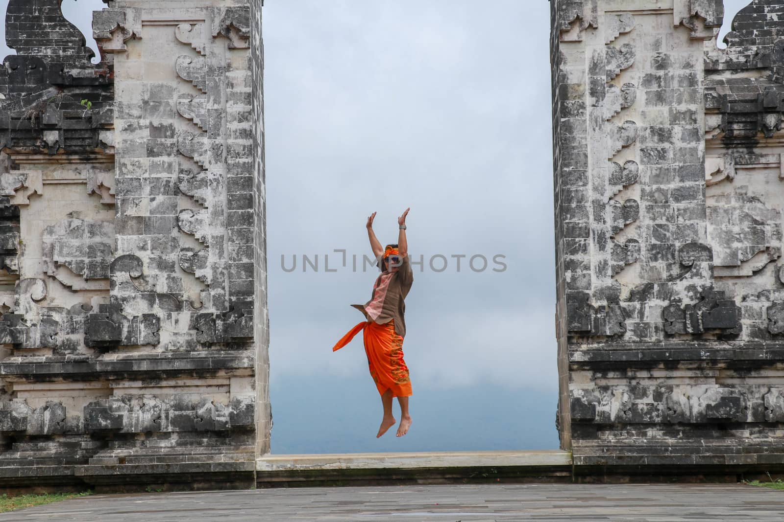 Bali, Indonesia. Traveler man jumping with energy and happiness in the gate of heaven. Lempuyang temple.