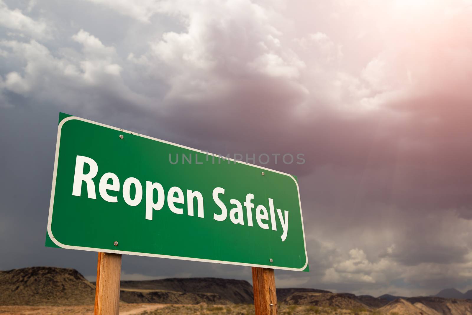 Reopen Safely Green Road Sign Against Ominous Stormy Cloudy Sky by Feverpitched