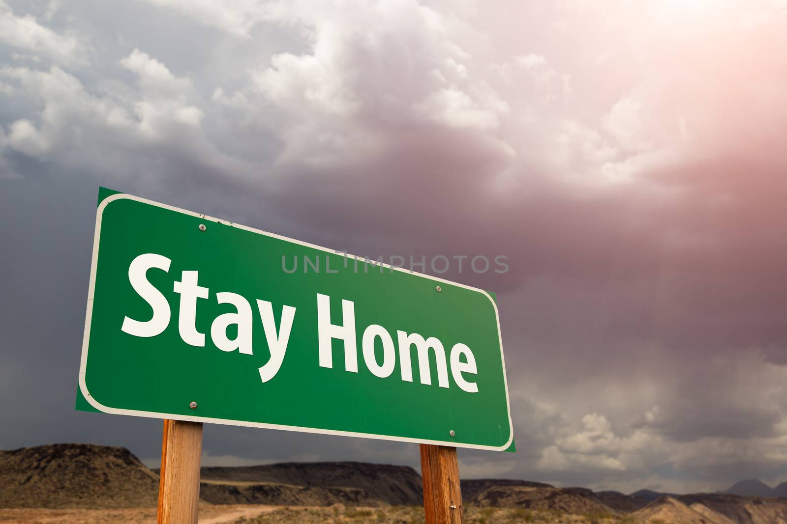 Stay Home Green Road Sign Against Ominous Stormy Cloudy Sky by Feverpitched