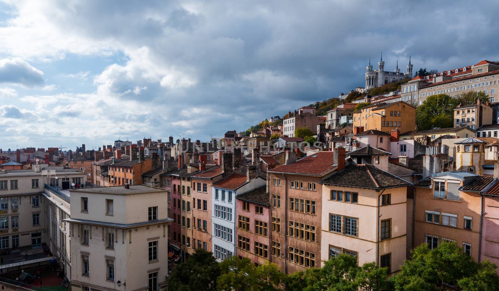 A wide angle photo of Lyon with the Basilica of Notre-Dame de Fourviere at the top of the hill.