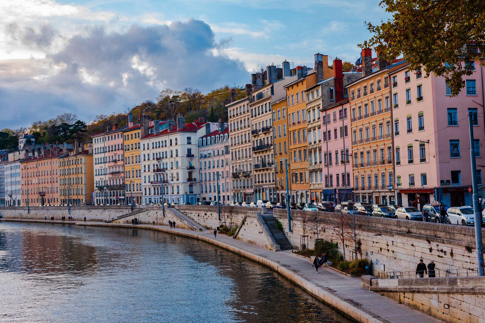 Lyon, France -- November 5, 2017 -- People, cars and colorful buildings on the bank of the Saone River in Lyon, France. Editorial Use Only.