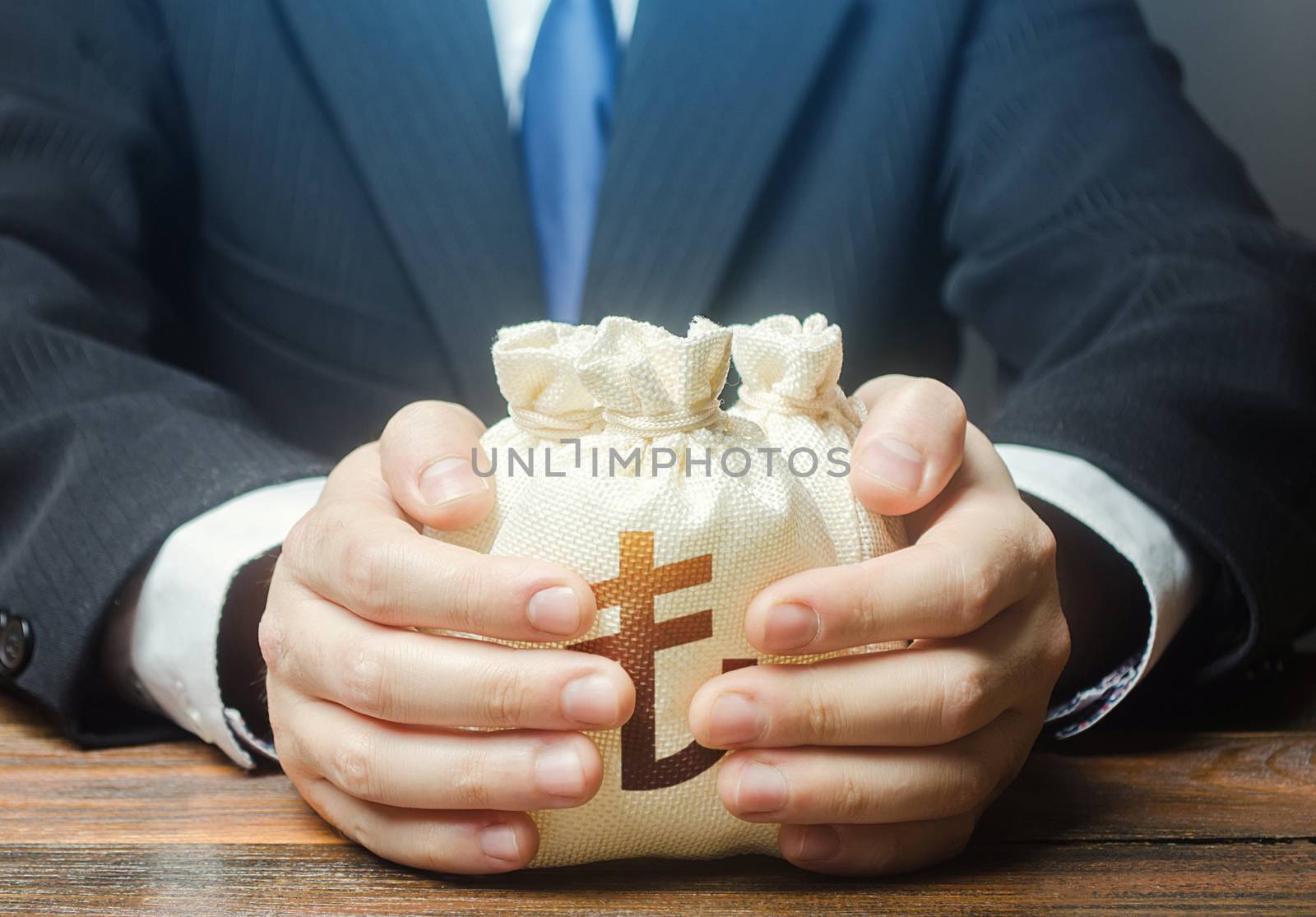 Businessman covers with hands turkish lira money bags. Accumulation of funds, bank loan. Investments. Corrupt schemes. Profit collection and tax withholding. Hit jackpot. Capital. Budget absorption