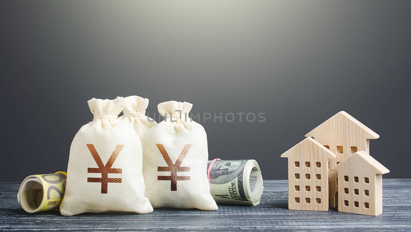Yen Yuan money bags and residential buildings figures. Investments in real estate. Financing the construction and renovation of housing. Municipal budget management. Subsidies. Taxes. Mortgage loan