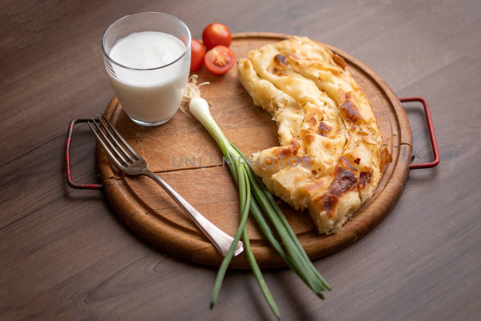 Traditional balkan breakfast - Borek or Burek pie with cheese aranged on wooden table