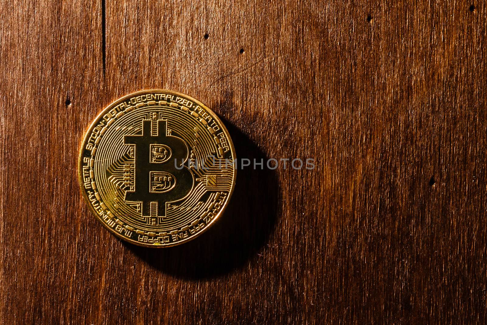 The golden bitcoin on wooden table and bokeh background, golden bitcoin symbol of bitcoin crytocurrency from blockchain technology.