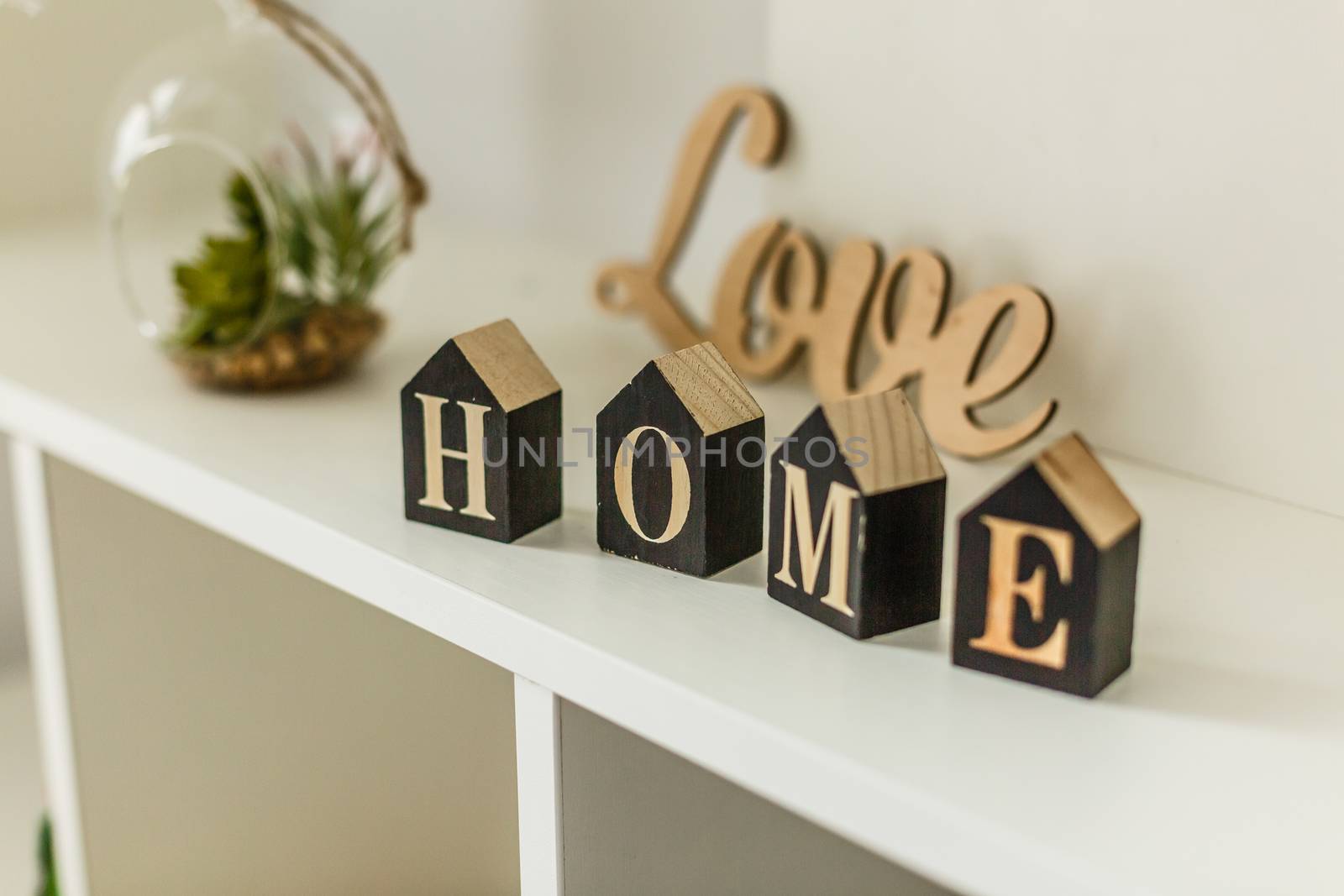Word home on white wooden background with copy space. Home word concept. Home word written on black wooden houses.