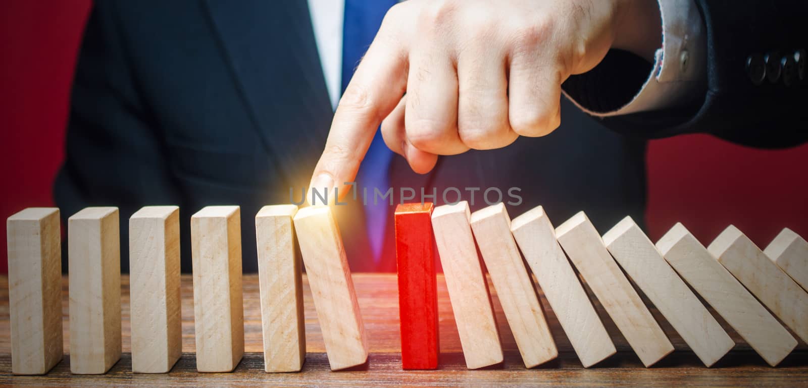 Businessman restarts the process of falling dominoes. Start work after stopping. Continuation of working, obstacle avoidance. maintainability. After the weekend. Correction of errors and malfunctions.