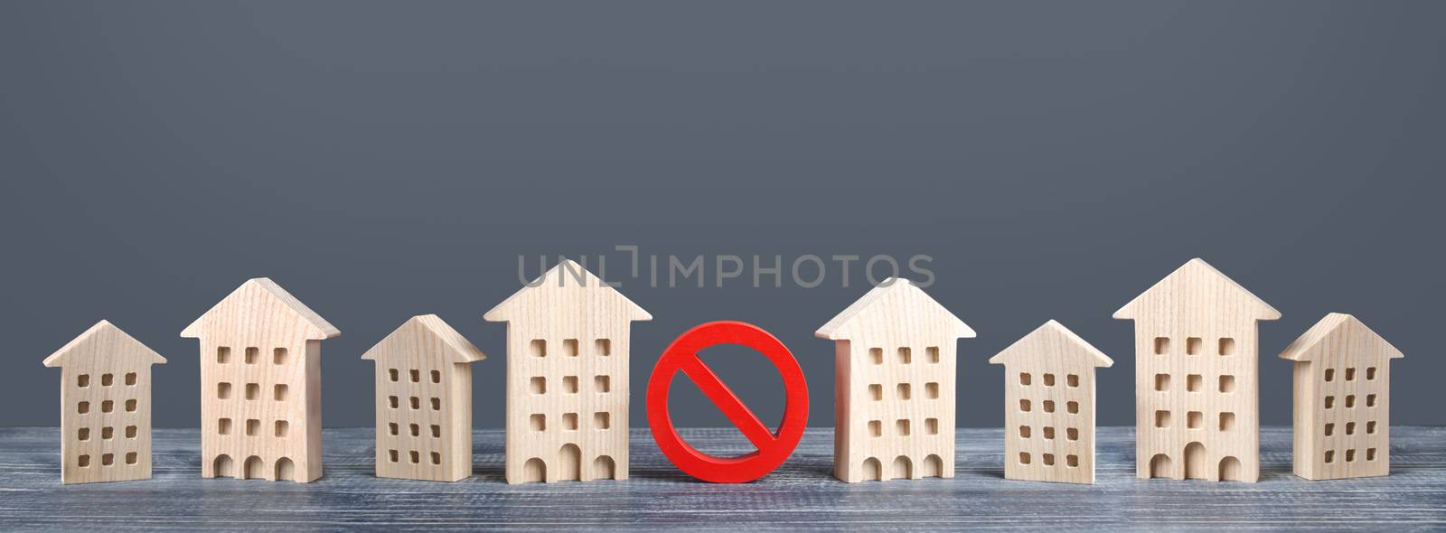 A red prohibition sign no stands among residential buildings. Restrictions ban on construction. Inaccessible expensive housing. Restriction building compaction. Underdeveloped infrastructure utilities by iLixe48
