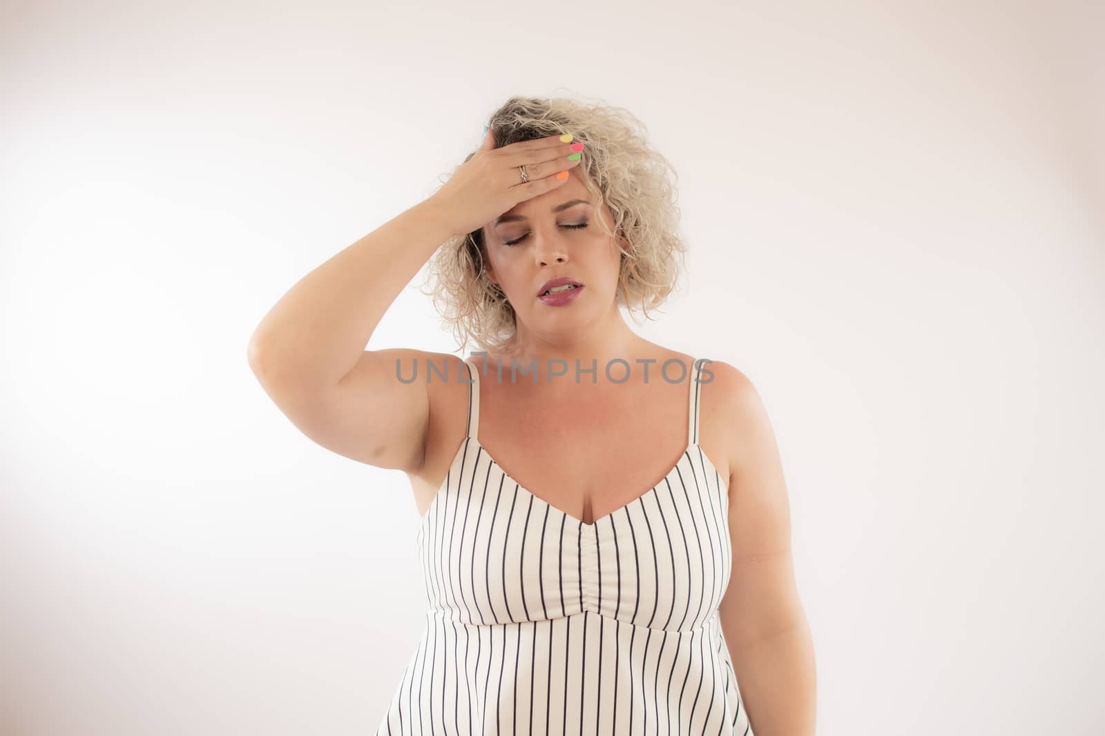 Blonde young woman with the gesture of headache