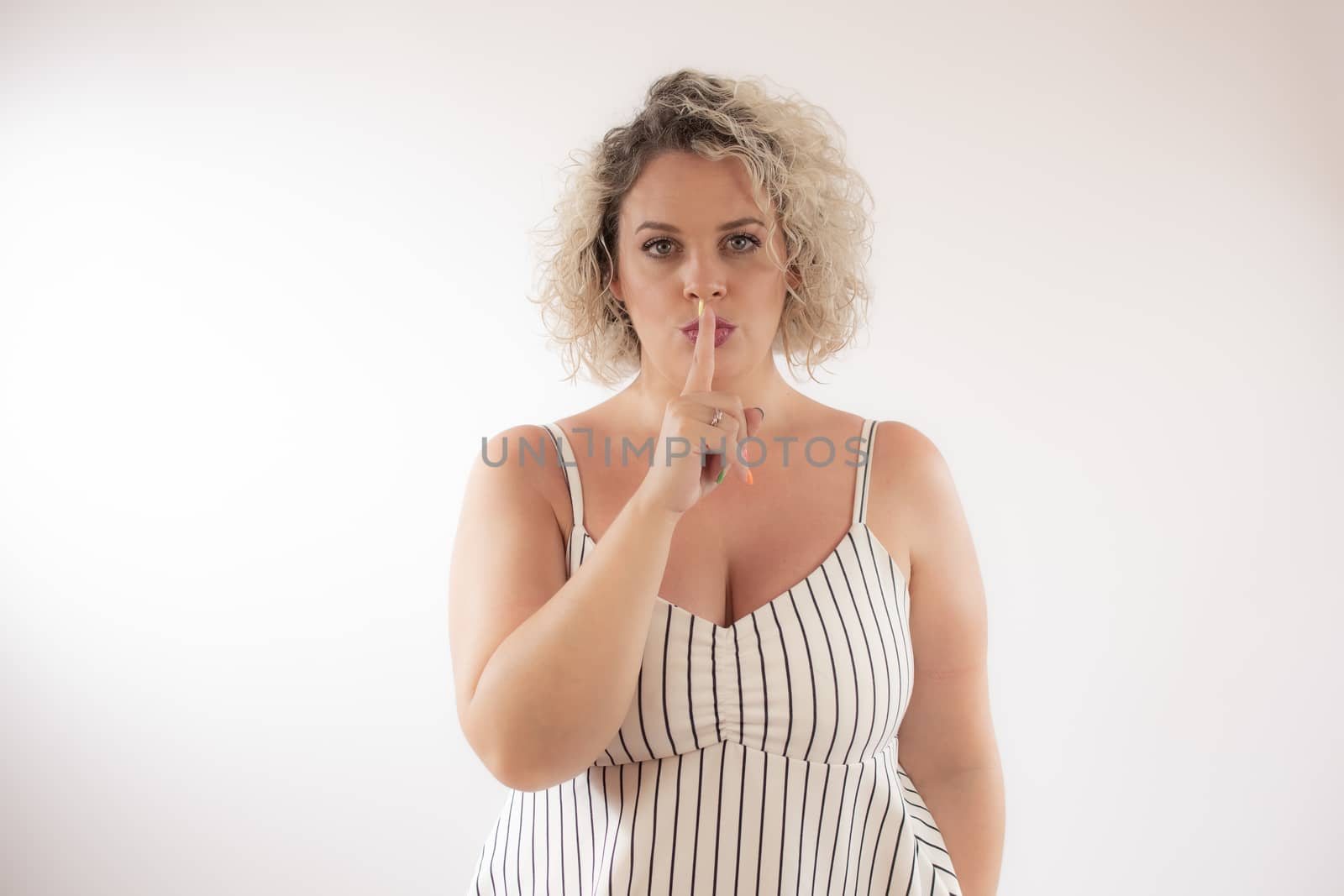 Blonde young woman with the gesture of silence