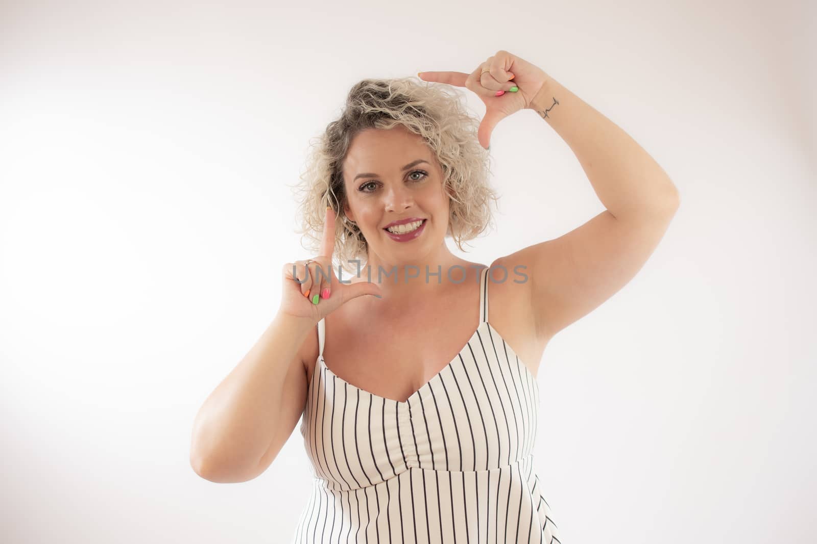 Blonde young woman making portrait gesture