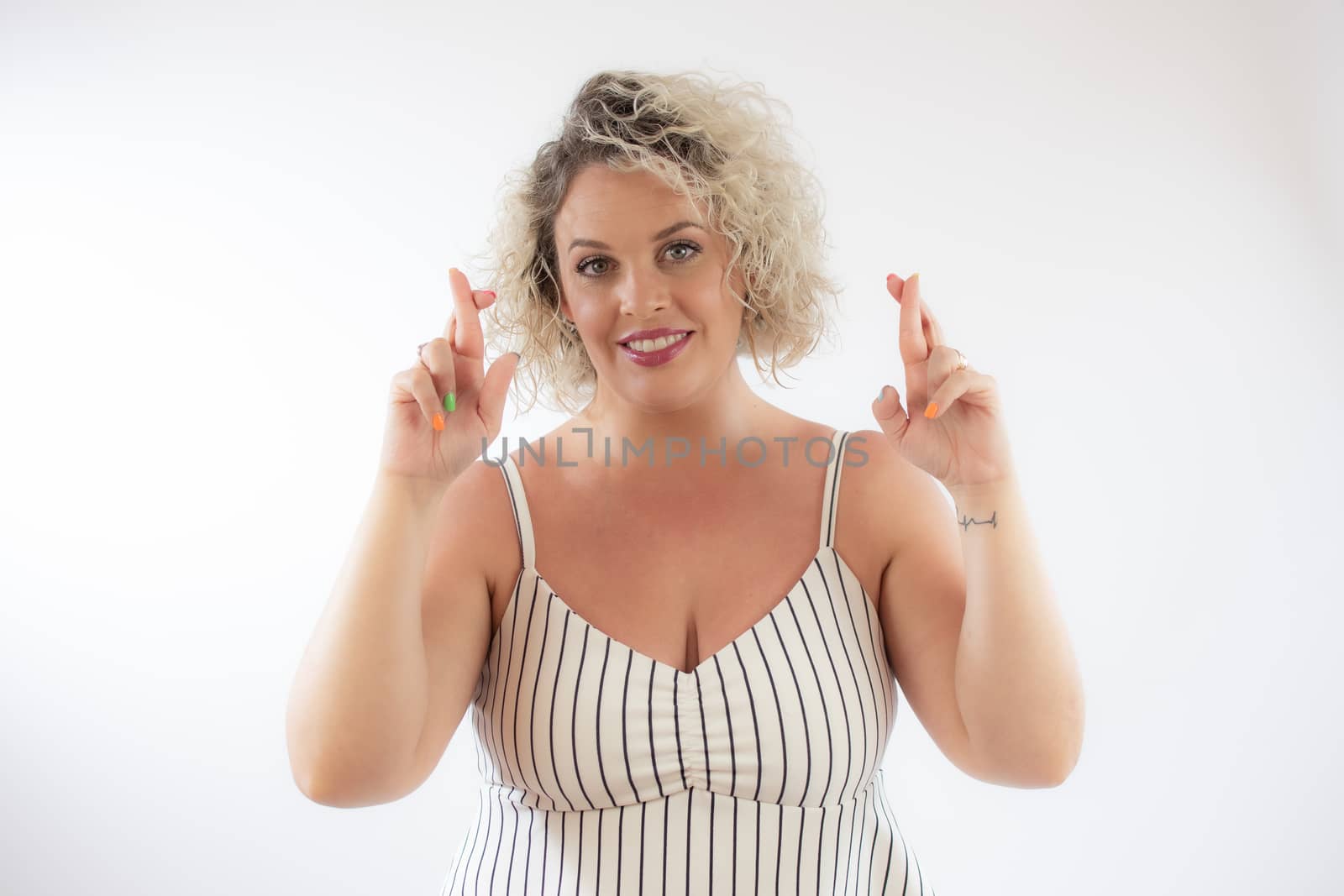 Blonde young woman with fingers crossed