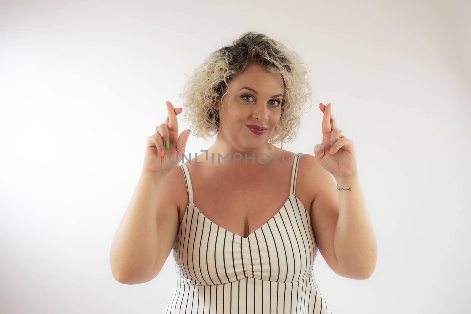 Blonde young woman with fingers crossed