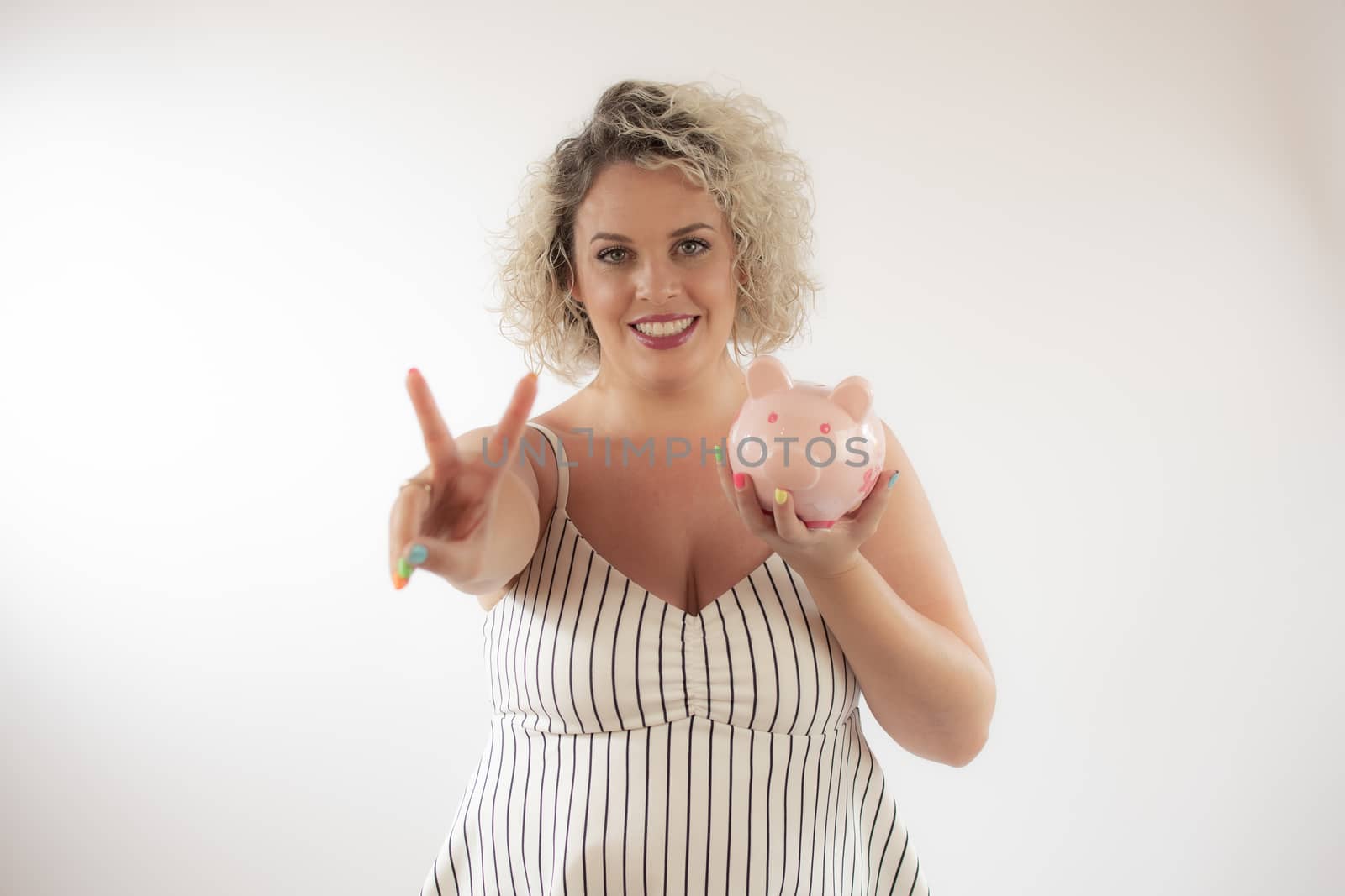 Blonde young woman with a piggy bank