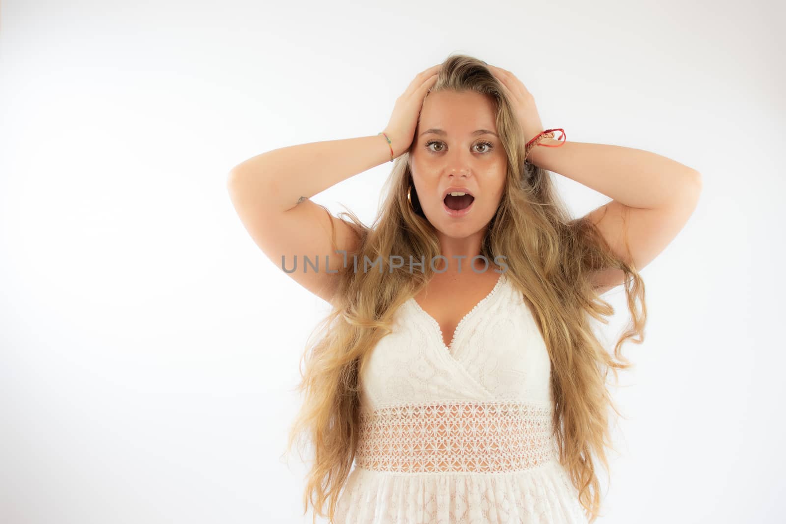 Pretty blonde girl in a white dress with the gesture of surprise