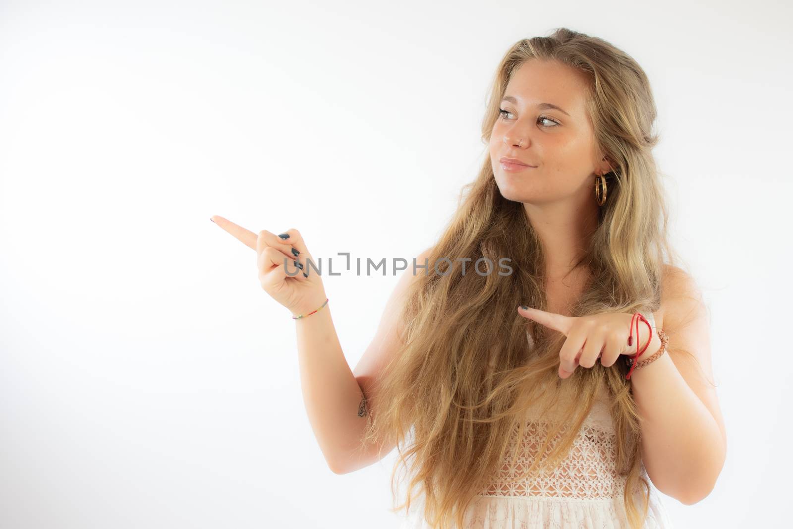 Pretty blonde girl in a white dress pointing with her fingers